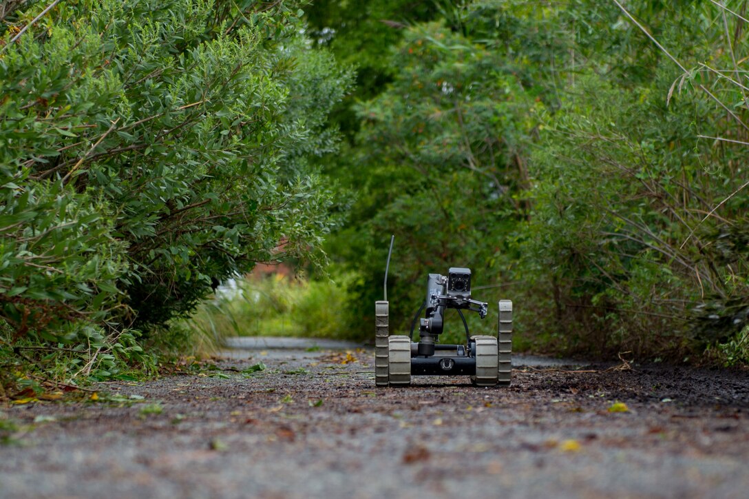 A robot is controlled by a U.S. Air Force Airman assigned to the 11th Civil Engineer Squadron Explosive Ordinance Disposal flight, as it approaches a training improvised explosive device during Operation Llama Fury three point zero at Joint Base Langley-Eustis, Virginia., August 8, 2017.