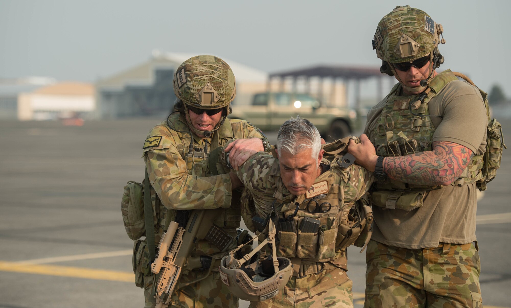 Royal Australian Air Force Leading Aircraftman Tobin Barwick, left, and RAAF Cpl. Adam Dahmer, escort a role player off the flightline during exercise Mobility Guardian at Moses Lake, Wash., Aug.7, 2017.  Approximately 650 international service members will work alongside more than 3,000 U.S. service members during Mobility Guardian.  The exercise is Air Mobility Command’s premier readiness exercise, providing an opportunity for the Mobility Air Forces to train with joint and international partners in airlift, air refueling, aeromedical evacuation and mobility support.  (U.S. Air Force photo by Staff Sgt. Robert Hicks)