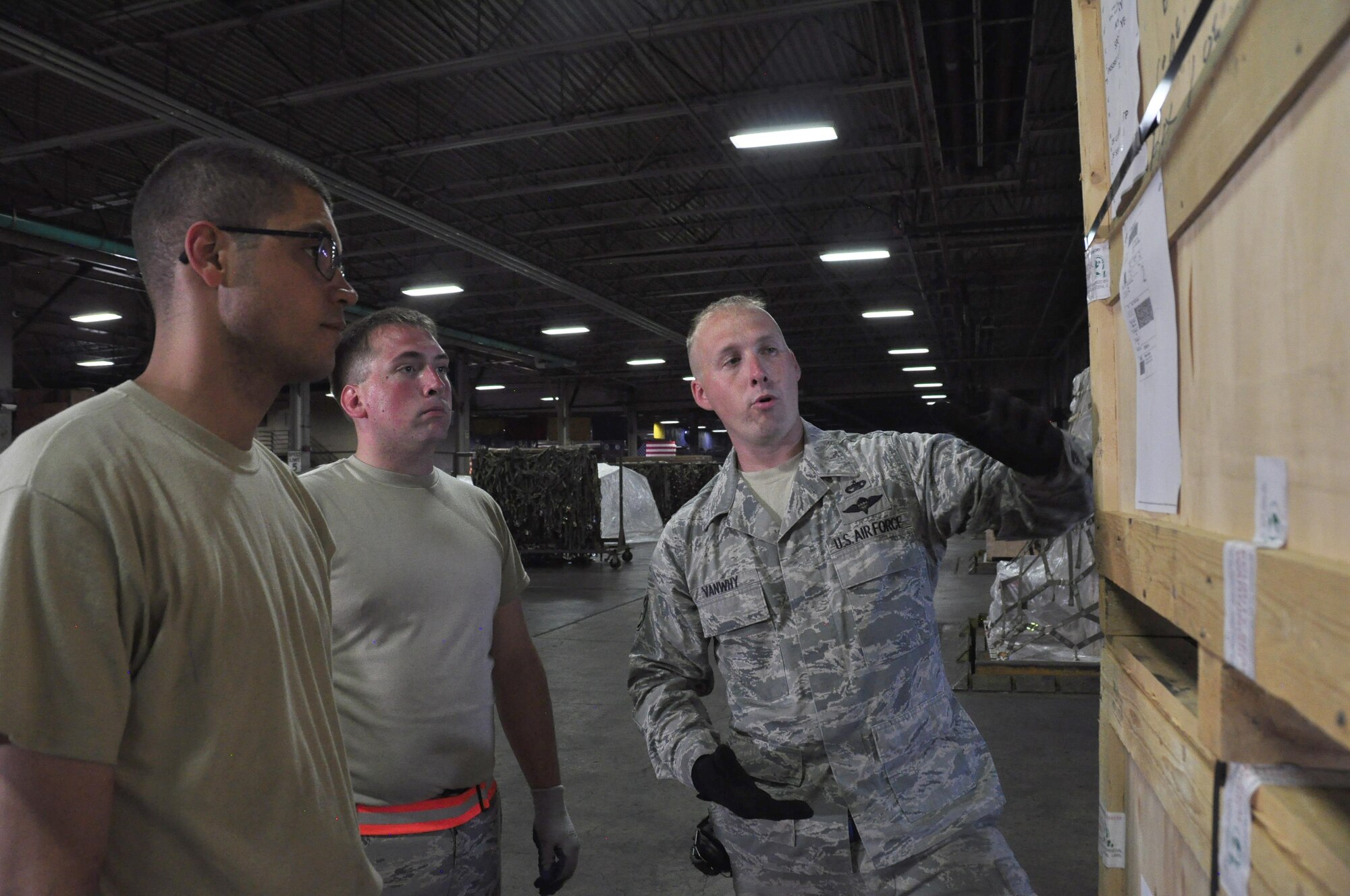 Staff Sgt. David Vanwhy, right, a 60th Aerial Port Squadron cargo operations shift supervisor, teaches Senior Airmen William Gates and Geoffery Piechowski, both 39th APS transportation technicians, how to ensure labels are properly marked and secured to cargo before being shipped off, at Travis Air Force Base, Calif., July 13, 2017.