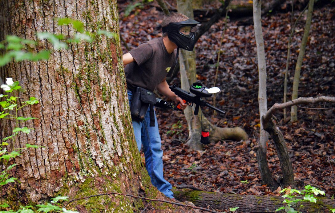After teen reloads his paintball gun he searches for his next target.
