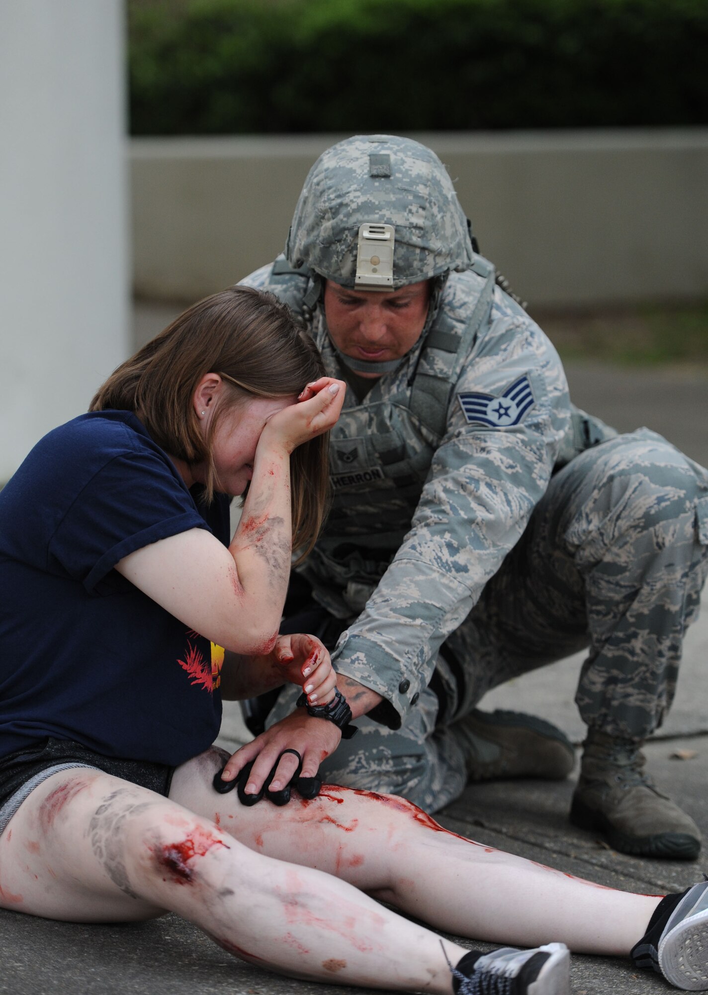 Staff Sgt. William Herron, 81st Security Forces Squadron military working dogs kennel master, aided Airman Basic Emily Payne, 335th Training Squadron student, as she portrays a “victim”  during an antiterrorism and Force Protection Condition exercise, Aug. 3, 2017, on Keesler Air Force Base, Miss. The scenario included a gate runner plowing into a student formation causing mass casualties. Wing and safety personnel designed the exercise to prepare Keesler personnel for potential real world situations. (U.S. Air Force photo by Kemberly Groue)