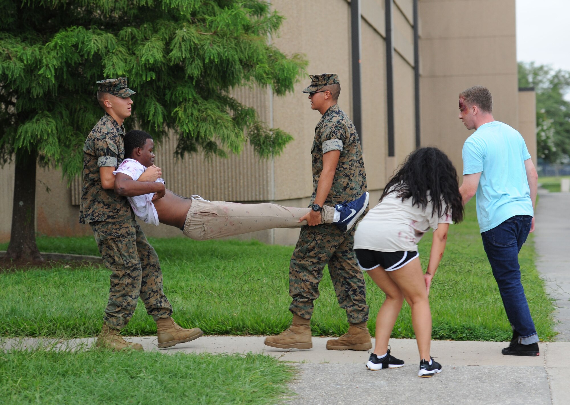 U.S. Marine Corps Lance Corporal Daniel Jarvis and Private 1st Class Roberto Moreno, Keesler Marine Detachment students, assist “victims” injured during an antiterrorism and Force Protection Condition exercise, Aug. 3, 2017, on Keesler Air Force Base, Miss. The scenario included a gate runner who plowed into a student formation causing mass casualties. Wing and safety personnel designed the exercise to prepare Keesler personnel for potential real world situations. (U.S. Air Force photo by Kemberly Groue)