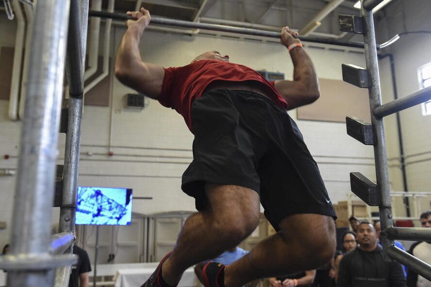 Tech. Sgt. Paul Woody, 437th Aircraft Maintenance Squadron special operations element chief, tries out the Alpha Warrior Battle Rig’s salmon ladder during its introduction on the Globemaster Court at the Air Base Fitness and Sports Center on Joint Base Charleston, S.C., Aug. 5. The salmon ladder is an obstacle where competitors throw a metal bar up onto a higher rung while hanging from the bar itself.
