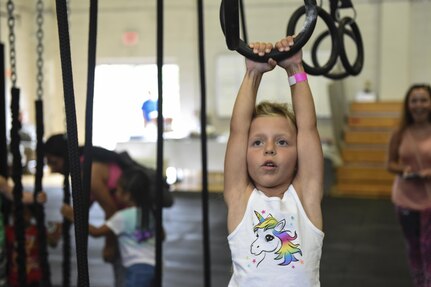 Lilah Slifer, Master Sgt. Chrissie Slifer, 437th Aircraft Maintenance Squadron gold section chief’s daughter, plays on the children’s rig during the Alpha Warrior Battle Rig’s introduction on the Globemaster Court at the Air Base Fitness and Sports Center on Joint Base Charleston, S.C., Aug. 5.