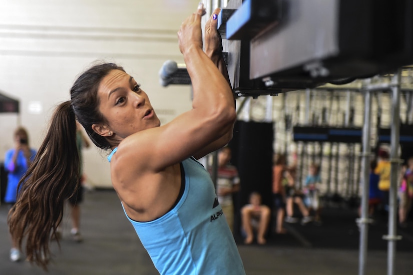 Rebekah Bonilla, Alpha Warrior pro-athlete, demonstrates how to take on the Alpha Warrior Battle Rig during its introduction on the Globemaster Court at the Air Base Fitness and Sports Center on Joint Base Charleston, S.C., Aug. 5.