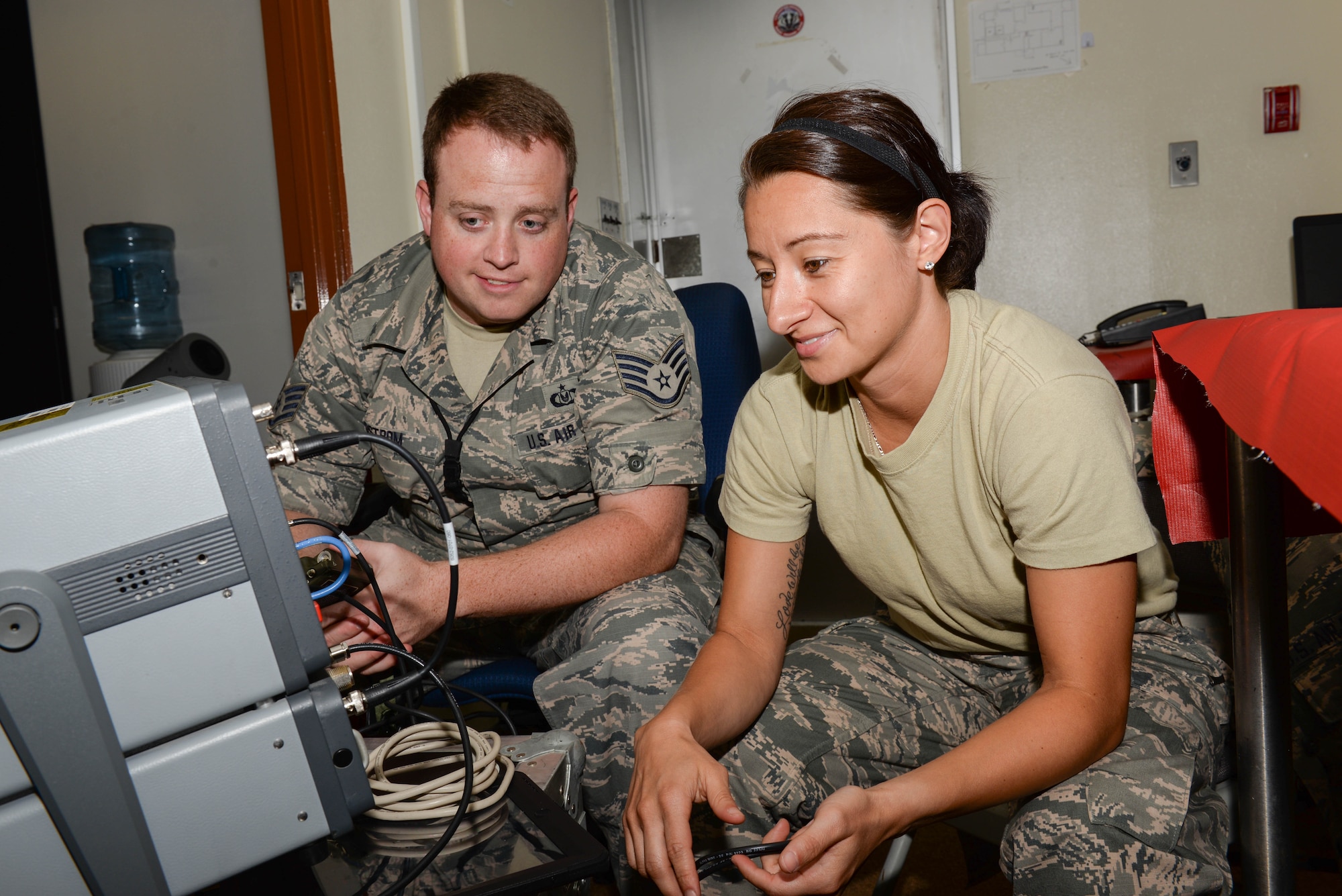 Two Airmen work on radio equipment