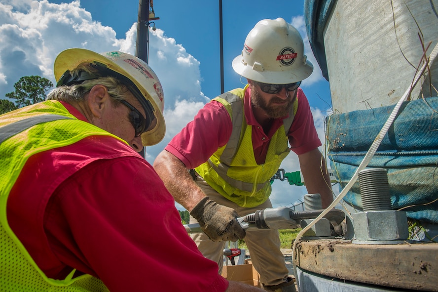 Local electricians secure bolts for a light fixture during Moody’s base-wide high efficiency lighting project, Aug. 7, 2017, at Moody Air Force Base, Ga. As part of the Department of Defense’s Energy Conservation Investment Program, the 23d Civil Engineer Squadron and local contractors conducted $3.6 million worth of repairs and replacements for the entire installation’s exterior and interior lighting. (U.S. Air Force photo by Senior Airman Greg Nash)
