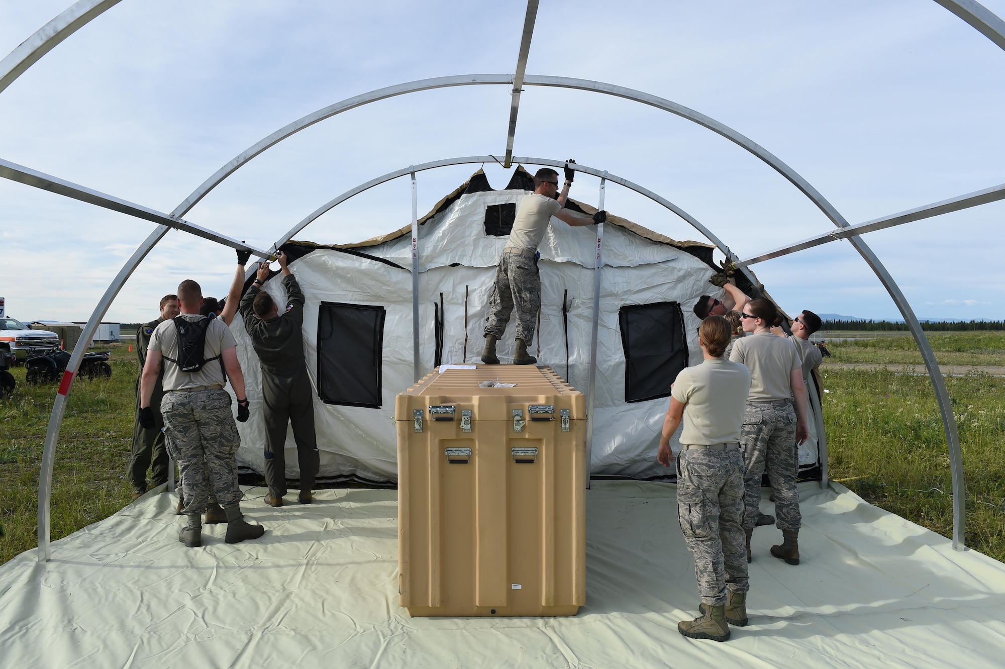 U.S. Air Force members with the 673rd Medical Group construct a tent during exercise Arctic ACE, Alaska, July 9, 2017. This joint exercise was meant to test capabilities from an austere location to include setting up and operating a bare base while simultaneously establishing and maintaining communications with home station in order to meet new challenges or missions in a dynamic environment.