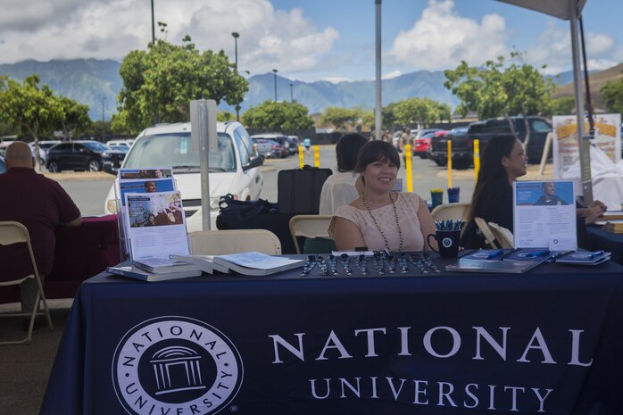 Ali Cresap, the admissions counselor at National University, sits at her resource table at Mokapu Mall during the Education Expo aboard Marine Corps Base Hawaii, August 3, 2017. U.S. Marines, Sailors, spouses, and DoD employees visited more than 20 tables to learn about college courses available after work and/or online classes. This is one of many services that the Education Center provides for active duty service members, family members, veterans, and DoD civilians on base to assist with starting or completing journeys towards a college degree or certificate program. (U.S. Marine Corps photo by Cpl. Zachary Orr)