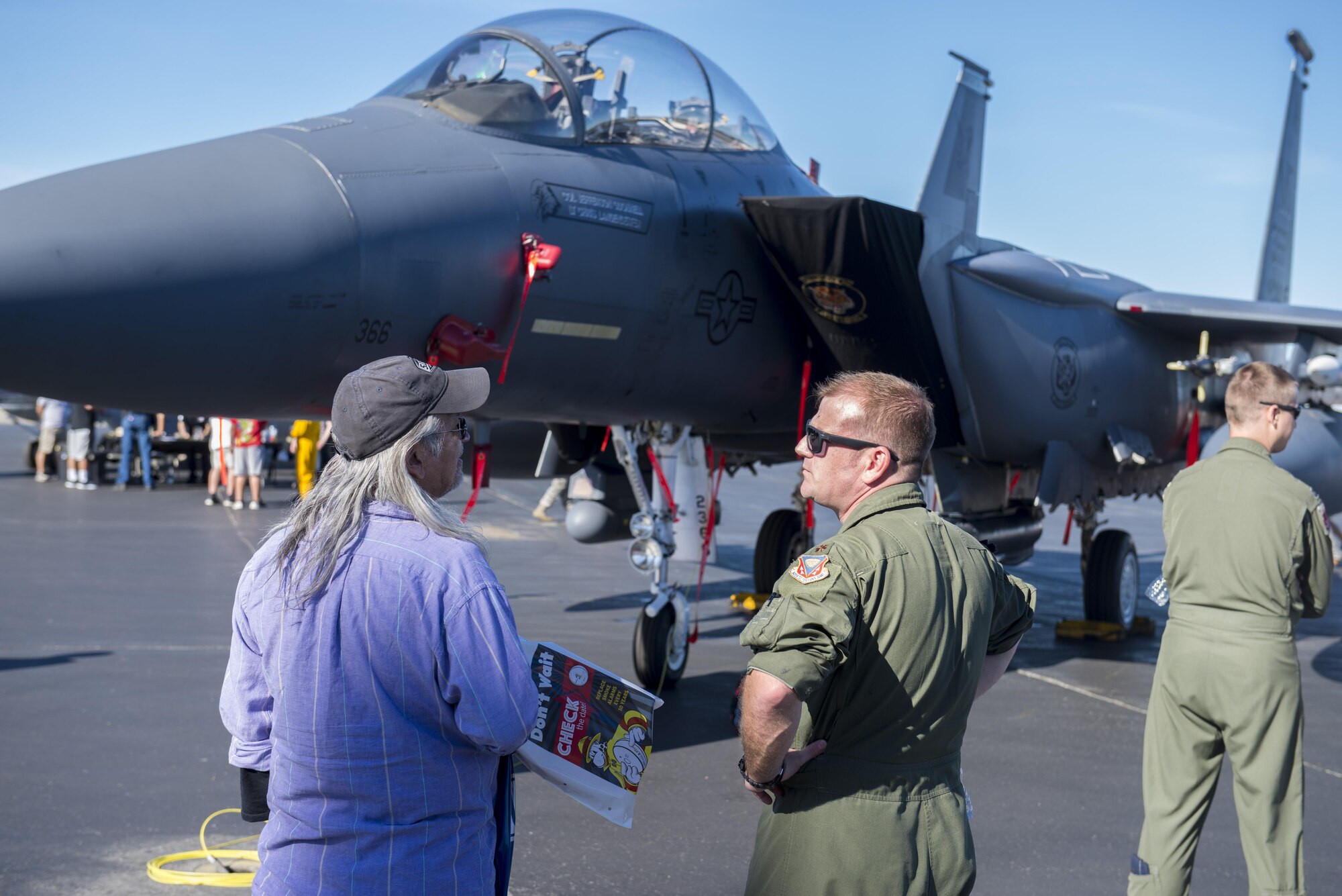 U.S. Air Force Maj. Ronald Davenport, an F-15E weapons system officer assigned to the 391st Fighter Squadron, Mountain Home Air Force Base (AFB), Idaho, speaks to a member of the local community during the Eielson AFB, Alaska, Open House, August 5, 2017. The event featured aircraft from multiple services and nations as well as presentations from the military working dogs and explosive ordnance disposal. (U.S. Air Force photo by Airman 1st Class Isaac Johnson)