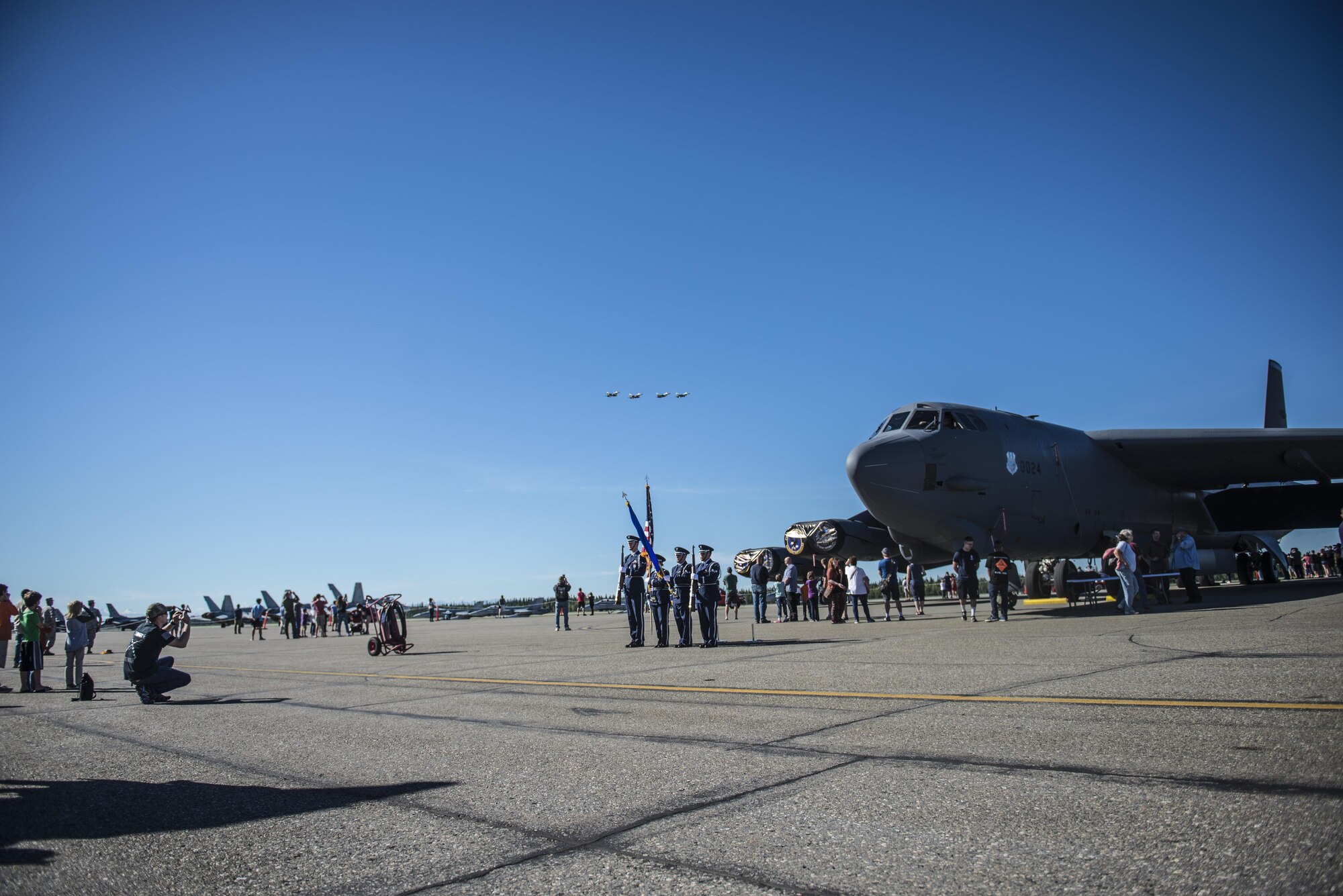 Eielson Air Force Base (AFB) Honor Guard present the colors during a flyover at the Eielson AFB Open House, August 5, 2017, Alaska. The Open House featured demonstrations by explosive ordnance disposal and the military working dogs, while also showcasing joint and coalition aircraft. (U.S. Air Force photo by Airman 1st Class Isaac Johnson)