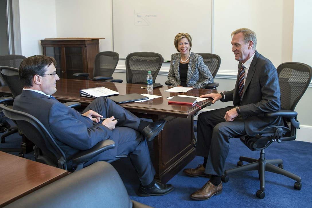 This image shows a group of three people meeting around a table.