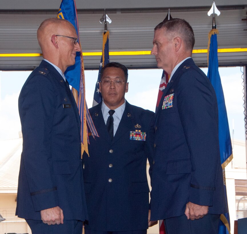 Col. Joseph Harris, commander, 154th Maintenance Group prepares to hand a guidon to Lt. Col. Henry Kaufman during a 154th Maintenance Squadron change of command ceremony