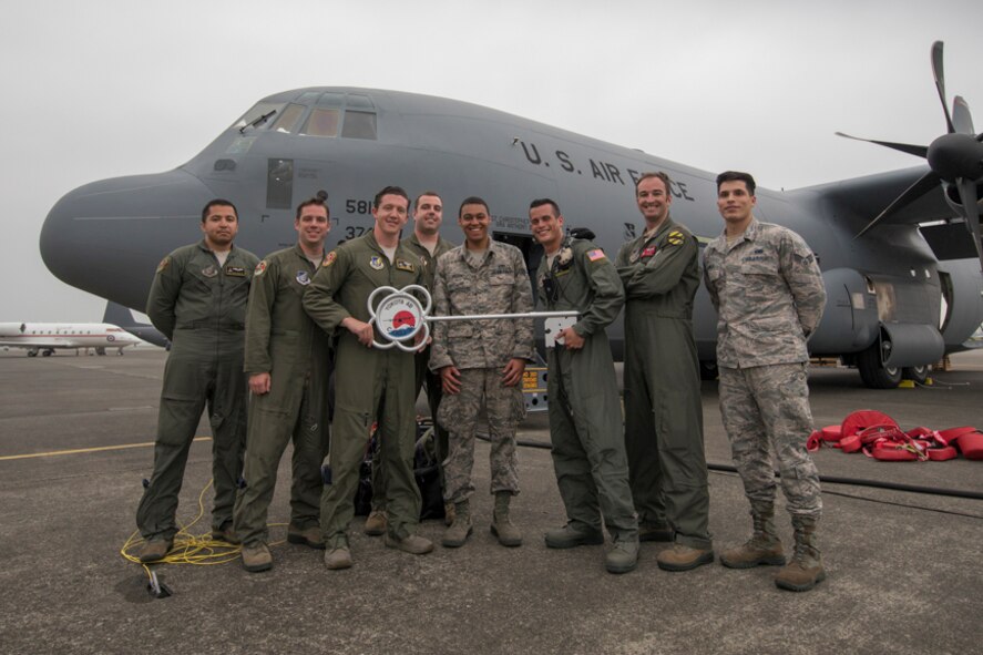 alt=Members of the C-130J delivery team pose for a photo in front of a C-130J Super Hercules