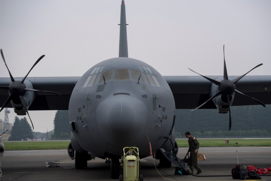alt=Crew member from the 36th Airlift Squadron unloads luggage from a C-130J Super Hercules