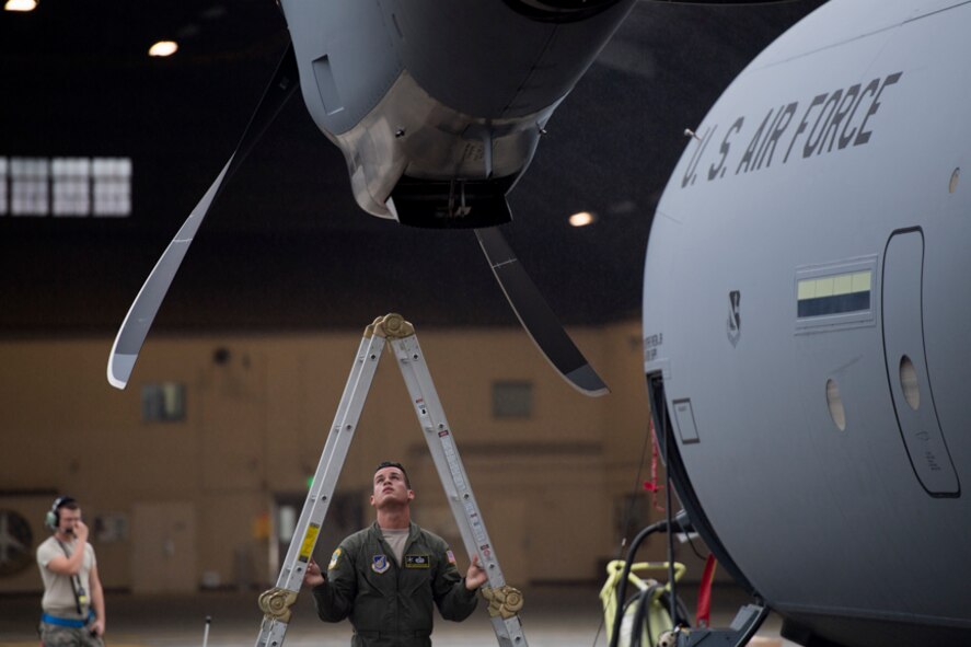alt=Staff Sgt. Christopher Rivera, 374th Aircraft Maintenance Squadron flight crew chief, performs a post-flight inspection