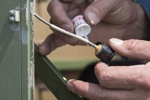 Steve Wagner, a Draughon Range electronic warfare field engineer, attaches a wire onto an unmanned threat emitter-receiver at Draughon Range at Misawa City, Japan, Aug. 2, 2017. The threat emitters provide a more realistic training experience for pilots by simulating enemy detection and attacks. Range personnel perform site checks around the area to survey for any necessary maintenance. (U.S. Air Force photo by Airman 1st Class Sadie Colbert)