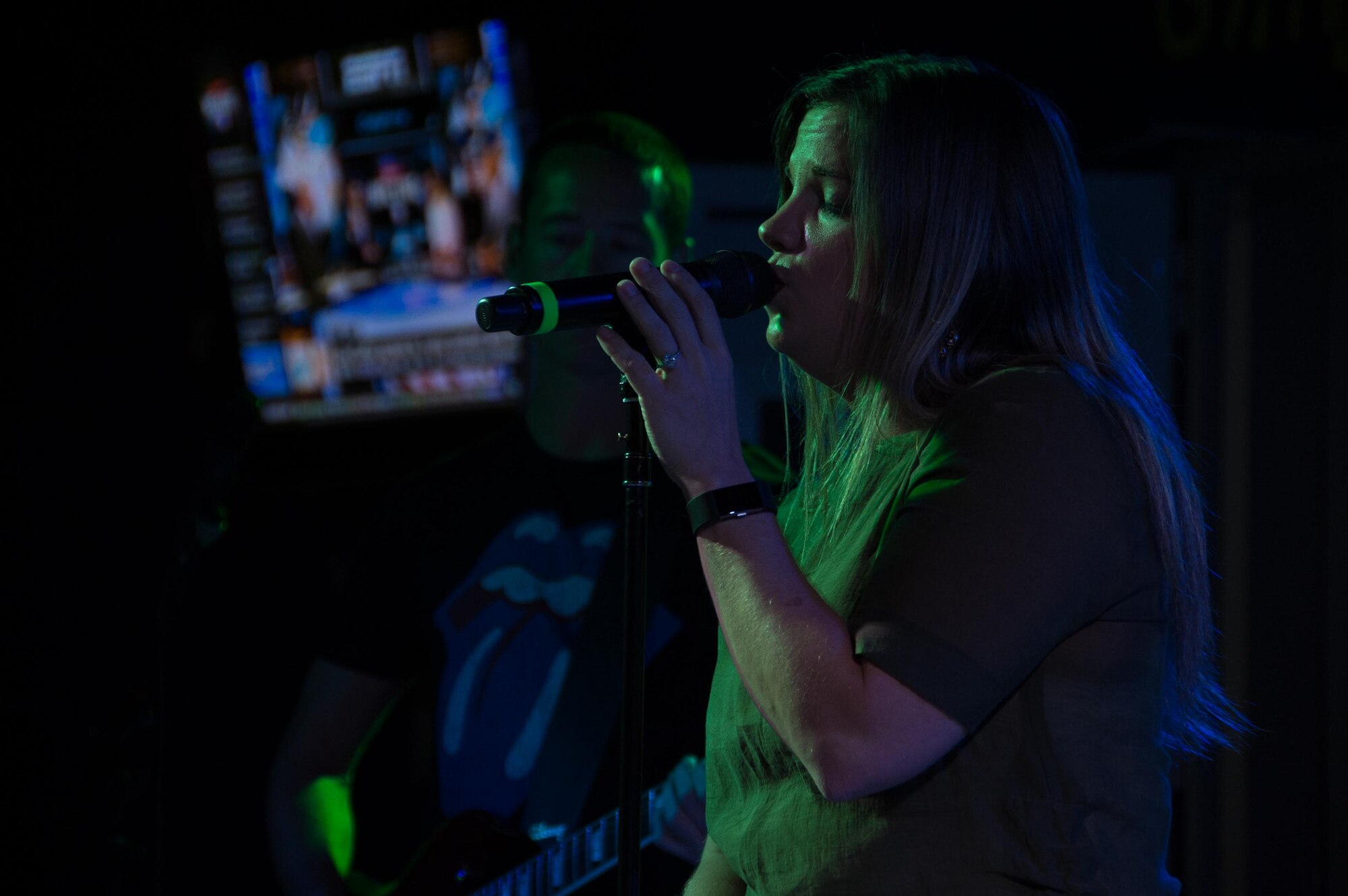 Staff Sgt. Melissa Lackore, one of the lead vocalists for the AFCENT Band, sings into the microphone during an AFCENT Band performance at an undisclosed location in Southwest Asia, August 7, 2017. The band’s high energy show and follow-on live band karaoke brought 386th Air Expeditionary Wing members and joint Coalition partners together for two nights of fun, laughter and fellowship. (U.S. Air Force photo by 1st Lt. Rashard Coaxum)