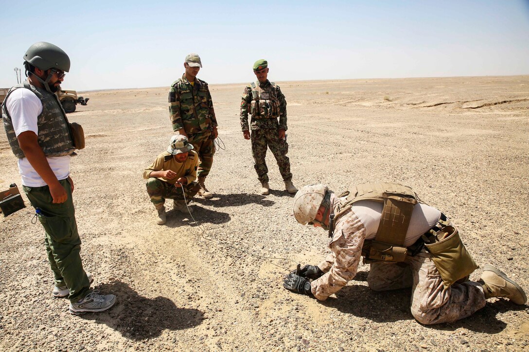 A U.S. Marine, right, sets a time fuse.