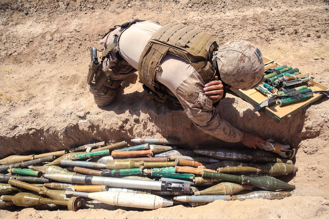 A U.S. Marine places unserviceable ammunition.