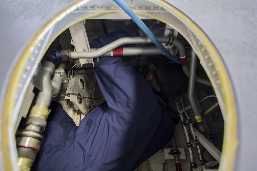 U.S. Air Force Senior Airman Edgar Gutierrez, 86th Maintenance Squadron fuel systems journeyman, inspects components inside the dry bay of fuel tank for a C-130J Super Hercules on Ramstein Air Base, Germany, Aug. 8, 2017. When the fuel door is open, Airmen are required to wear a gas mask, gloves, and protective coveralls for their safety. (U.S. Air Force photo by Senior Airman Tryphena Mayhugh)