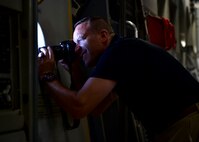 A civic leader takes a photograph from the window of a C-17 Globemaster III July 27, 2017. Those aboard spent their 3 hour flight exploring the air craft and taking they turns on the flight deck