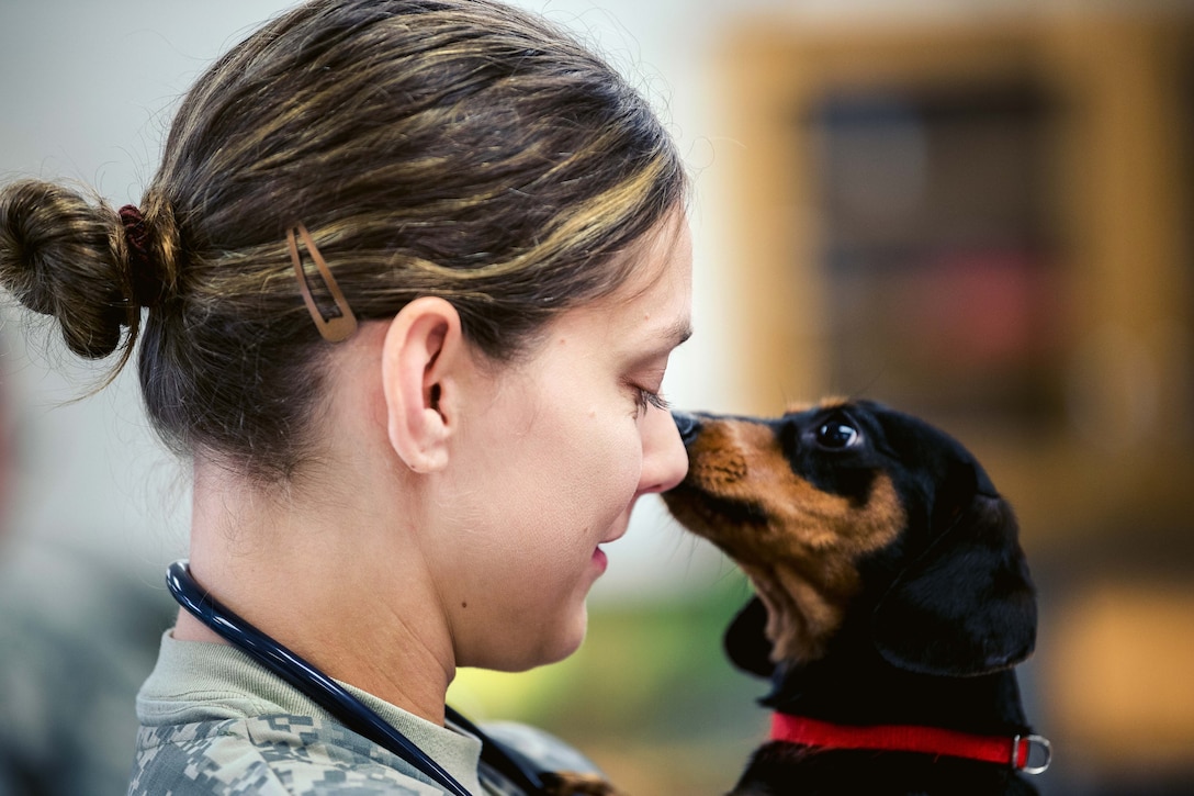Army Capt. Janet Johnston shares a moment with a dog named Maggie.