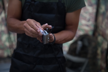 BRIDGEPORT, CALIF. - U.S. Navy LT. Mark Won, the chaplain for Combat Logistics Battalion 5, Combat Logistics Regiment 1, 1st Marine Logistics Group, lubricates his clippers during the Mountain Training Exercise 4-17 at Marine Corps Mountain Warfare Training Center, July 31, 2017. (U.S. Marine Corps photo by Lance Cpl. Timothy Shoemaker)