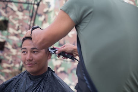 BRIDGEPORT, CALIF. - U.S. Navy LT. Mark Won, the chaplain for Combat Logistics Battalion 5, Combat Logistics Regiment 1, 1st Marine Logistics Group, cuts Second Lieutenant Karl Watje’s hair during the Mountain Training Exercise 4-17 on the Marine Corps Mountain Warfare Training Center July 31, 2017. (U.S. Marine Corps photo by Lance Cpl. Timothy Shoemaker)