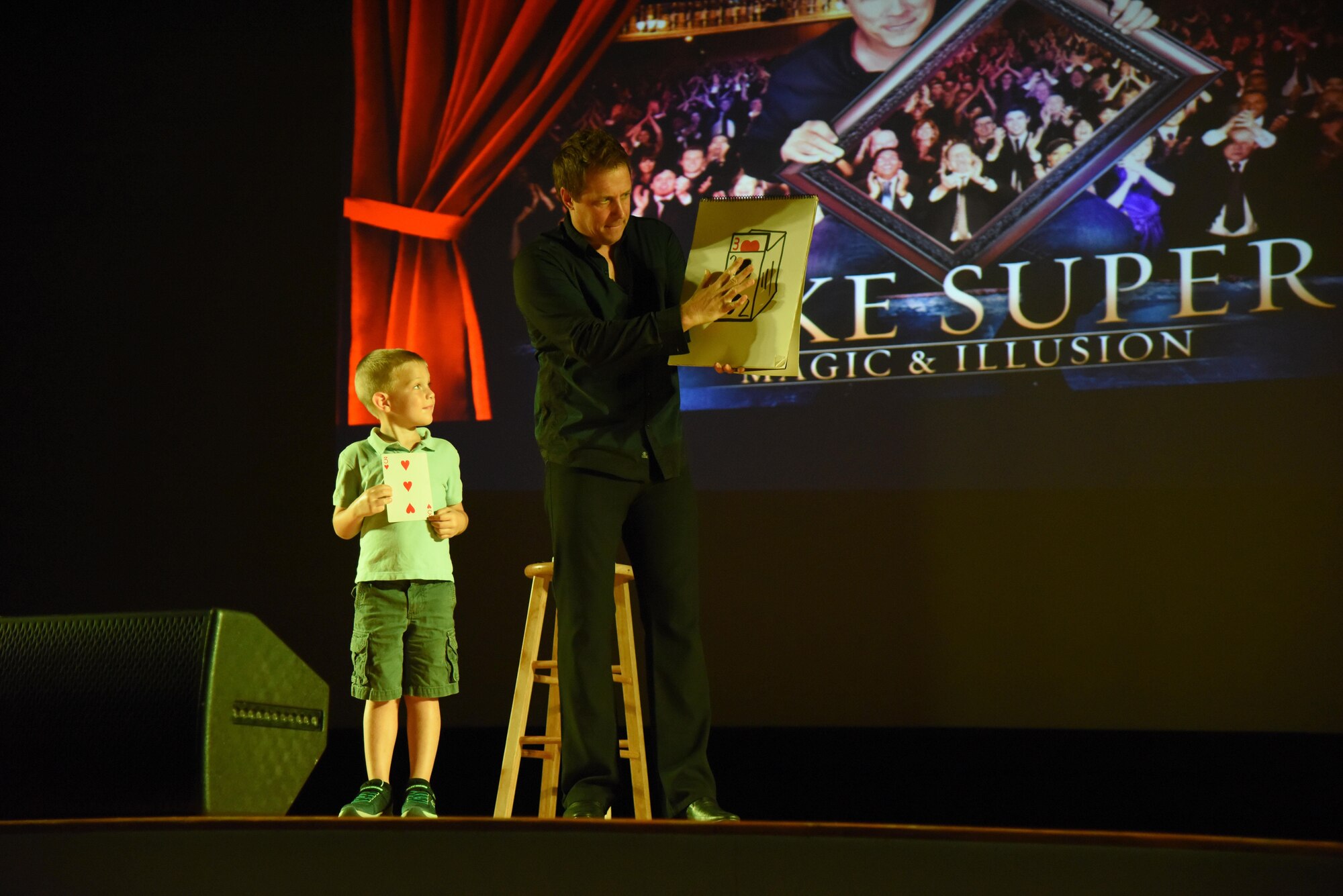 Mike Super, illusionist, performs a card trick with the assistance of Jackson Hedin, son of Maj. Cory Hedin, 81st Diagnostic and Therapeutics Squadron pharmacy operations chief, during the Mike Super’s Magic & Illusion show in the Welch Theater July 29, 2017, on Keesler Air Force Base, Miss. Super, an American magician who is the winner of the NBC show Phenomenon, is currently touring the U.S. and Canada with his illusion show. (U.S. Air Force photo by Kemberly Groue)