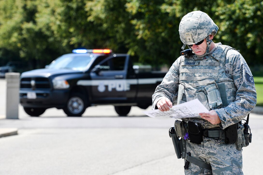 Airman reviews blueprints, listens to radio traffic during active-shooter exercise.