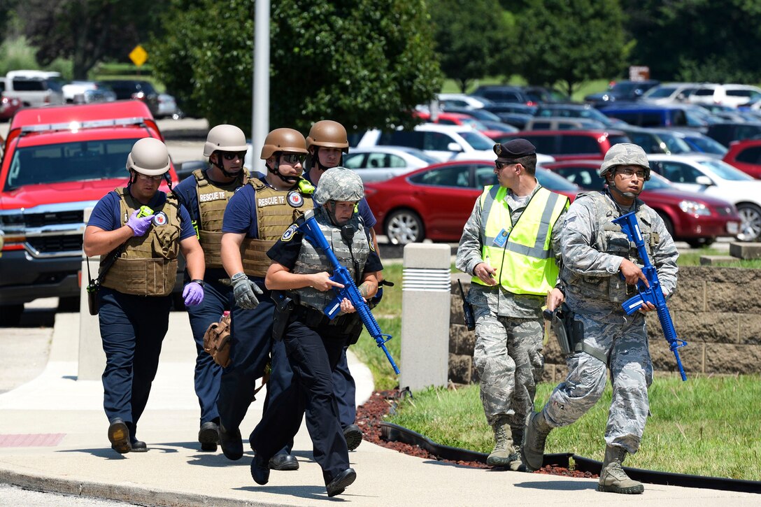 Security airmen escort medical personnel into the National Air and Space Intelligence Center.
