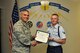 U.S. Air Force Col. Alex Ganster, 17th Training Group Commander, presents the 315th Training Squadron Student of the Month award for July 2017 to Airman 1st Class Tanner Scheidecker in Brandenburg Hall on Goodfellow Air Force Base, Texas, August 4, 2017. The 17th Training Wing's mission is to develop and inspire exceptional intelligence, surveillance and reconnaissance, and fire protection professionals for America and her allies. (U.S. Air Force photo by Russell Stewart/Released)
