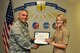 U.S. Air Force Col. Alex Ganster, 17th Training Group Commander, presents the 316th Training Squadron Student of the Month award for July 2017 to Lance Cpl. Britta Atkinson in Brandenburg Hall on Goodfellow Air Force Base, Texas, August 4, 2017. The 17th Training Wing's mission is to develop and inspire exceptional intelligence, surveillance and reconnaissance, and fire protection professionals for America and her allies. (U.S. Air Force photo by Russell Stewart/Released)