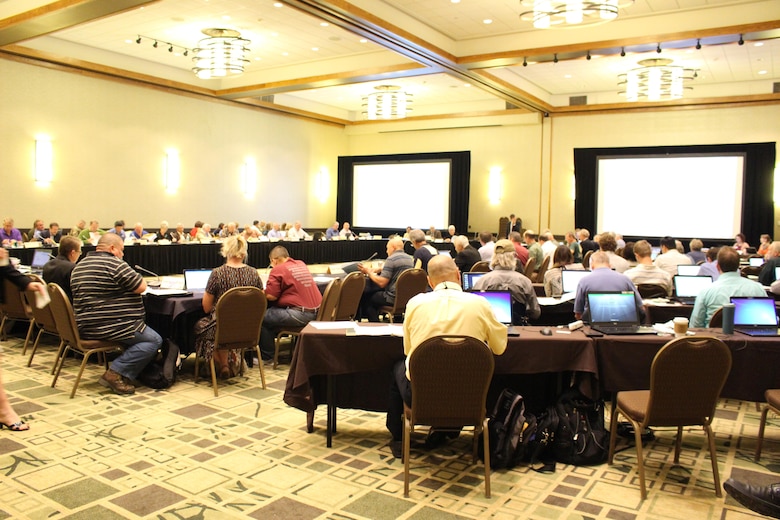 Members at tables in a conference room.