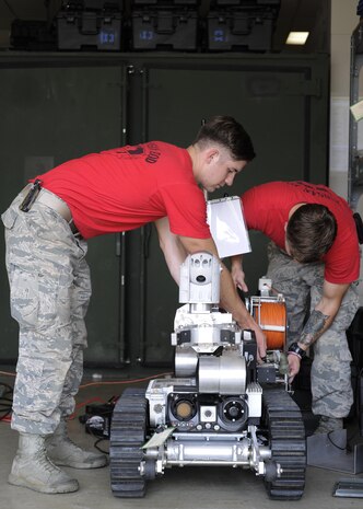 U.S. Air Force Airmen assigned to the 8th Civil Engineer Squadron Explosive Ordinance Disposal team, controls an Air Force Medium Sized Robot at Kunsan Air Base, Republic of Korea, Aug. 11, 2017. Airmen from both Osan Air Base and Kunsan Air Base, Republic of Korea had the opportunity to train with an instructor from Remotec, who supply and maintain AFMSRs and other robots for the Air Force, in rebuilding and repairing inoperable robots. (U.S. Air Force photo by Staff Sgt. Victoria H. Taylor)
