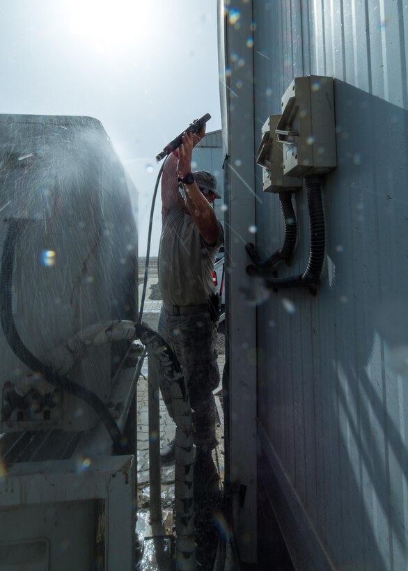 Tech. Sgt. James, 380th Expeditionary Civil Engineer Squadron heating, ventilation, and air conditioning technician, washes air conditioner condenser coils August 8, 2017, at Al Dhafra Air Base, United Arab Emirates.