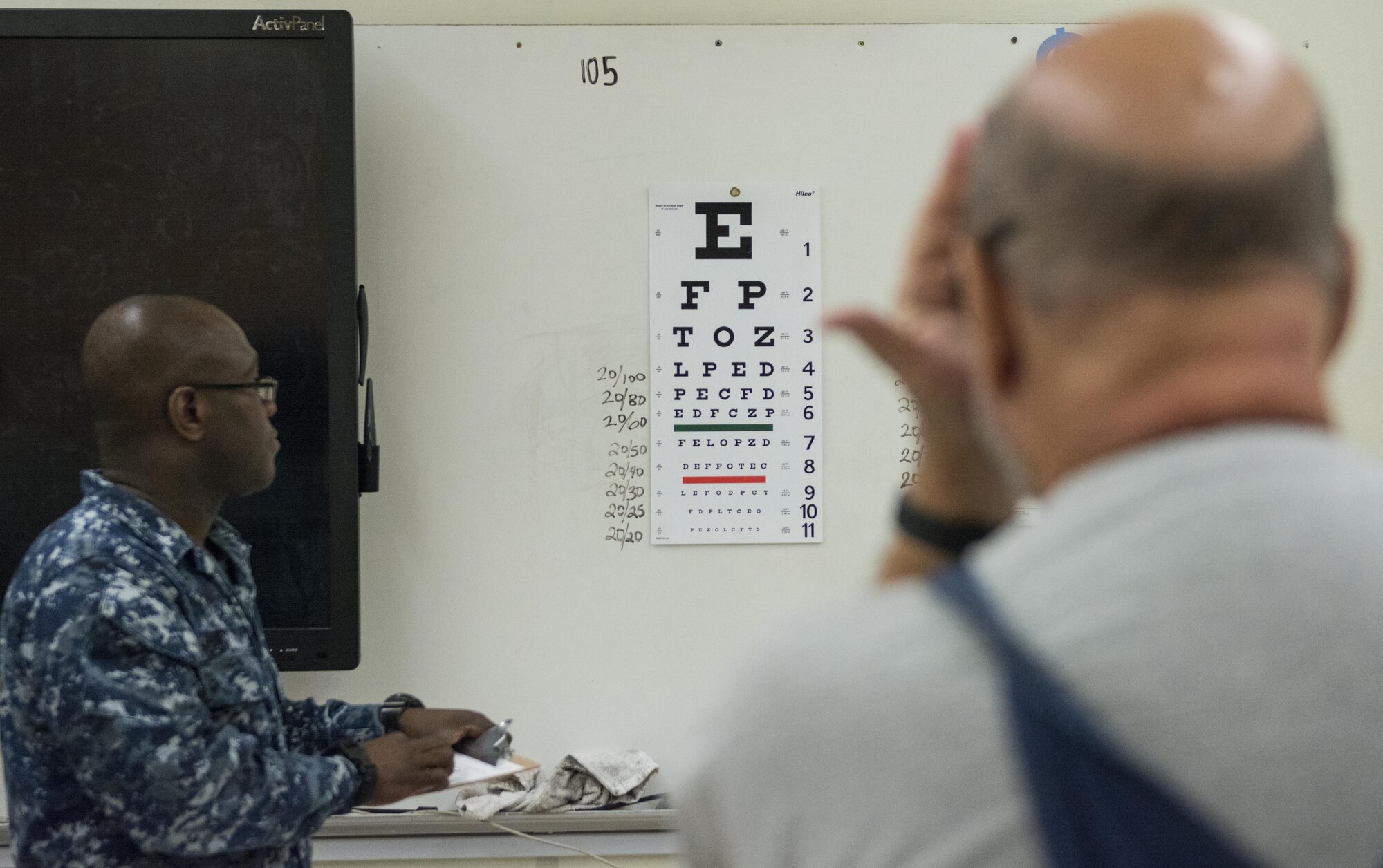 Navy HM2 Jeremiah King, a corpsman assigned to EMF Bathesda Naval Reserve Unit, Md. performs an eye exam on a patient at Swain County High School during Smoky Mountain Medical Innovative Readiness Training in Bryson City, N.C., on Aug. 3, 2017.