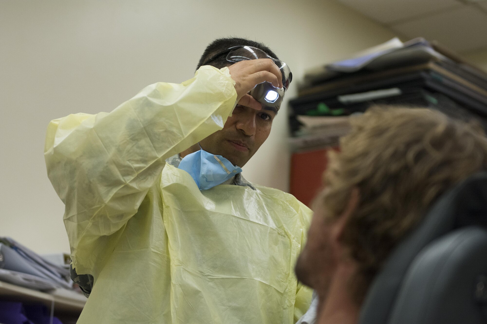 Army Capt. Anshuman Rawat, a dentist assigned to 455th Dental Company, Fort Devens Reserve Forces Training Area, Mass., examines a patient's teeth at Swain County High School during Smoky Mountain Medical Innovative Readiness Training in Bryson City, N.C., on Aug. 3, 2017.