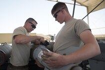 Tech. Sgt. Chris Brunsman installs a tail assembly onto a bomb body as Senior Airman David Paris holds the part in place at Bagram Airfield, Afghanistan, Aug. 4, 2017. Brunsman and Paris, who are munition systems specialists assigned to the 455th Expeditionary Maintenance Squadron, built guided bomb units to be used for combat operations in Afghanistan. (U.S. Air Force photo by Staff Sgt. Benjamin Gonsier)