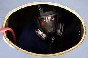 Senior Airman Stefan Stephenson-Shipp, 19th Maintenance Squadron fuel systems journeyman, enters a C-130J dry bay to reinstall a fuel manifold August 8, 2017, at Little Rock Air Force Base, Ark. All personnel entering a fuel tank or dry bay with open fuel lines are required to have a supplied air respirator on to prevent exposure to fumes. (U.S. Air Force photo/Airman 1st Class Kevin Sommer Giron)