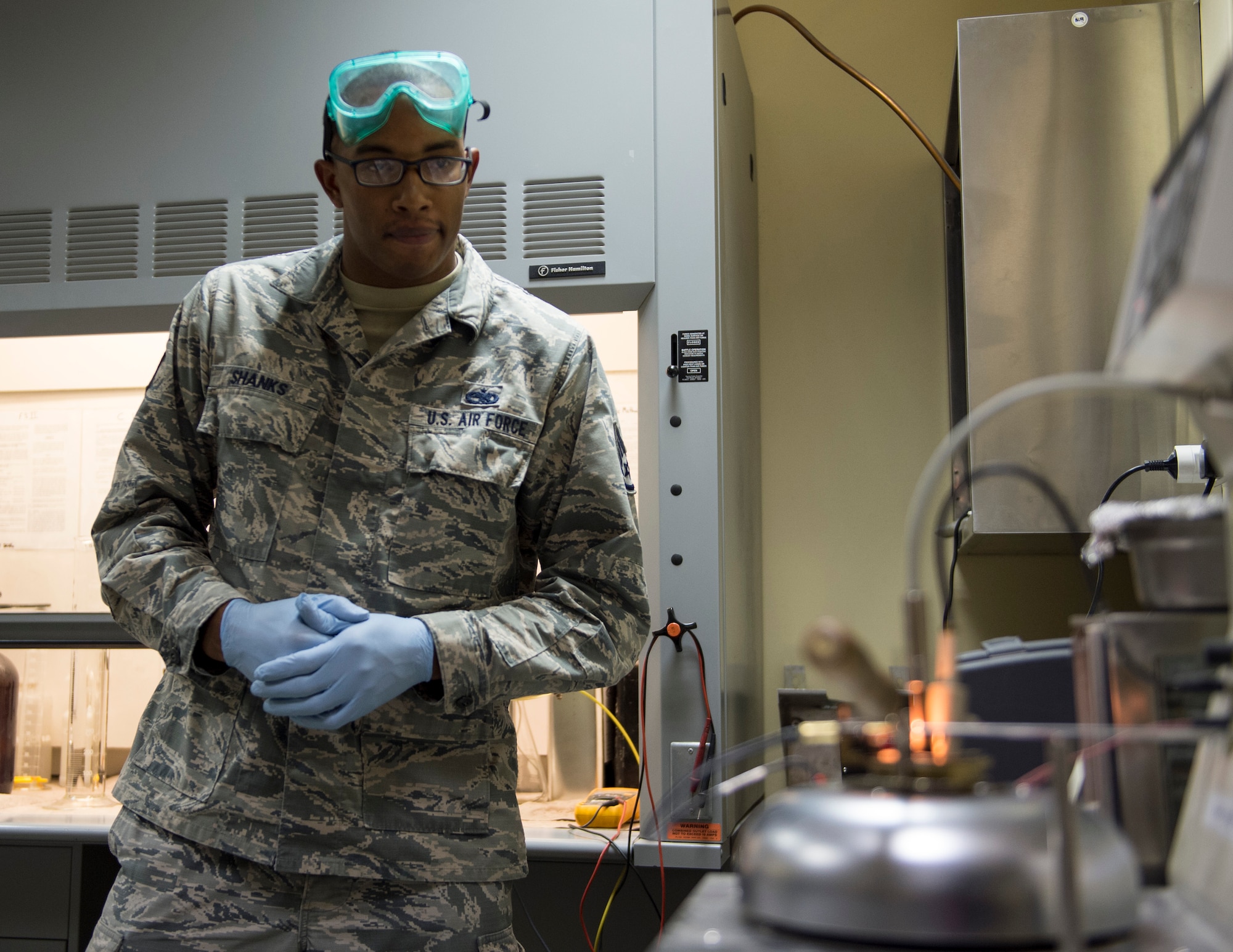 U.S Air Force Staff Sgt. Mario Shanks, non-commission officer in charge of the fuels lab with the 379th Expeditionary Logistics Readiness Squadron, Fuels Management Flight, watches the flash-point tester at Al Udeid Air Base, Qatar, July 24, 2017.