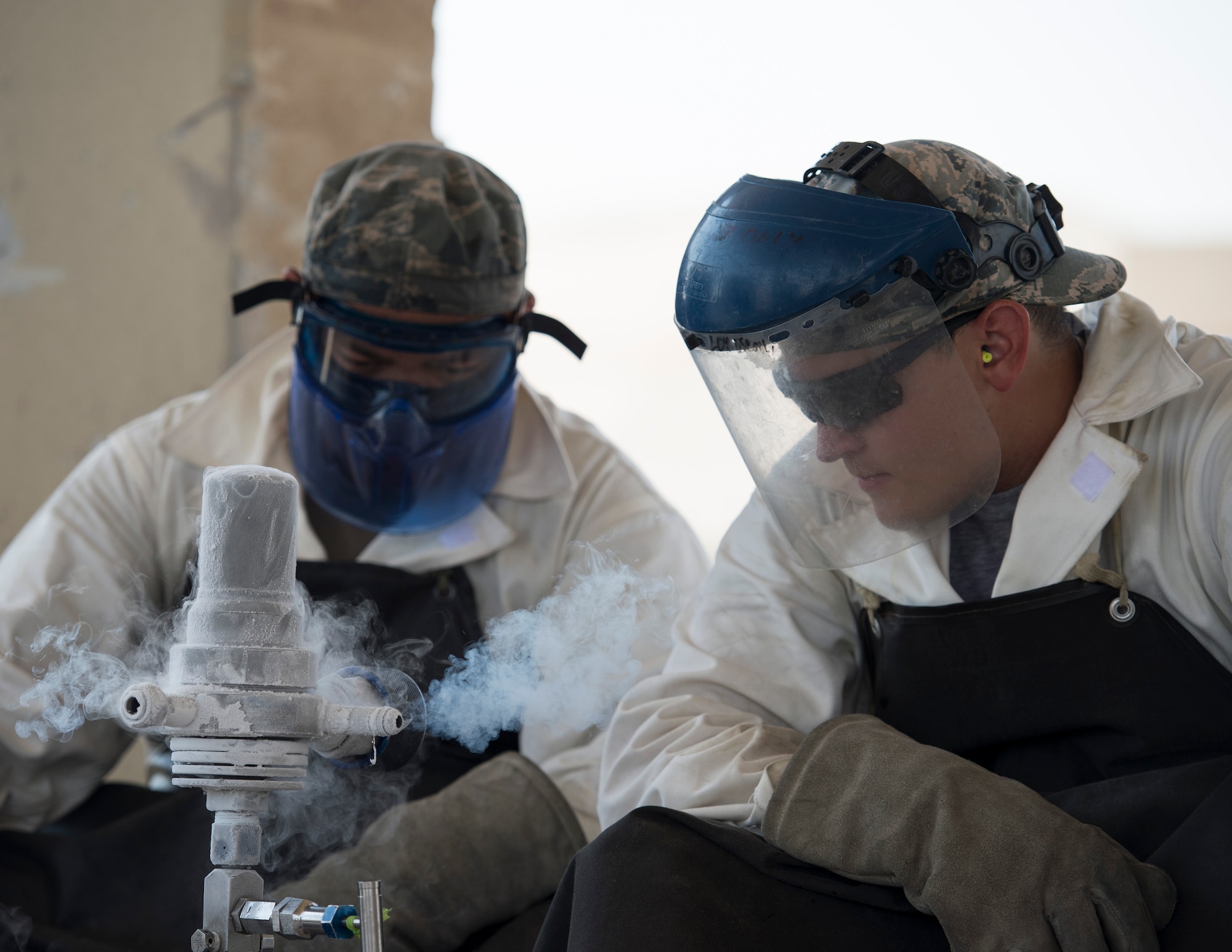 U.S. Air Force Staff Sgt. Kennie Delmo, left, a cryogenics supervisor and Senior Airman Samuel Fallot, a cryogenics journeyman with the 379th Expeditionary Logistics Readiness Squadron, Fuels Management Flight, wait for the pounds per square inch levels to increase on the cryogenic sampler at Al Udeid Air Base, Qatar, Aug. 9, 2017.