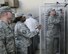 U.S. Air Force Master Sgts. Adam Lund, left, and Christina Southall, middle, incoming and outgoing kitchen managers respectively, assigned to the 379th Expeditionary Services Flight, look on as Technical Sgt. Alina Ness, right, non-commissioned officer of food safety and sanitation assigned to the Public Health Element of the 379th Expeditionary Medical Group checks a cold food storage unit during a kitchen inspection at the dining facility at Al Udeid, Air Base, Qatar, July 22, 2017. The five members of the 379th EMDG/SGOL work behind the scenes to ensure the health of Airmen deployed here by inspecting public facilities, clearing Airmen for forward deployment by ensuring they are properly vaccinated by tracking and working to prevent the spread of communicable diseases. (U.S. Air National Guard photo by Tech. Sgt. Bradly A. Schneider/Released)