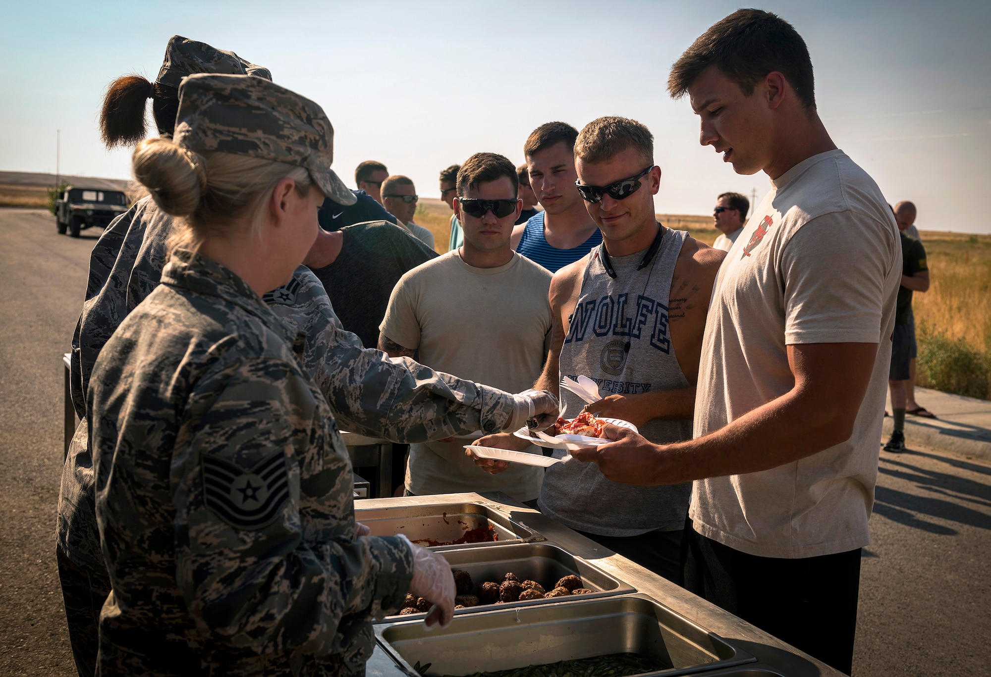 Airmen with the 182nd Civil Engineer Squadron, Illinois Air National Guard, receive dinner in Crow Agency, Mont., Aug. 1, 2017. Force Support Squadron services specialists provided meal support to the unit members while they built veterans’ homes for the Innovative Readiness Training program. (U.S. Air National Guard photo by Tech. Sgt. Lealan Buehrer)