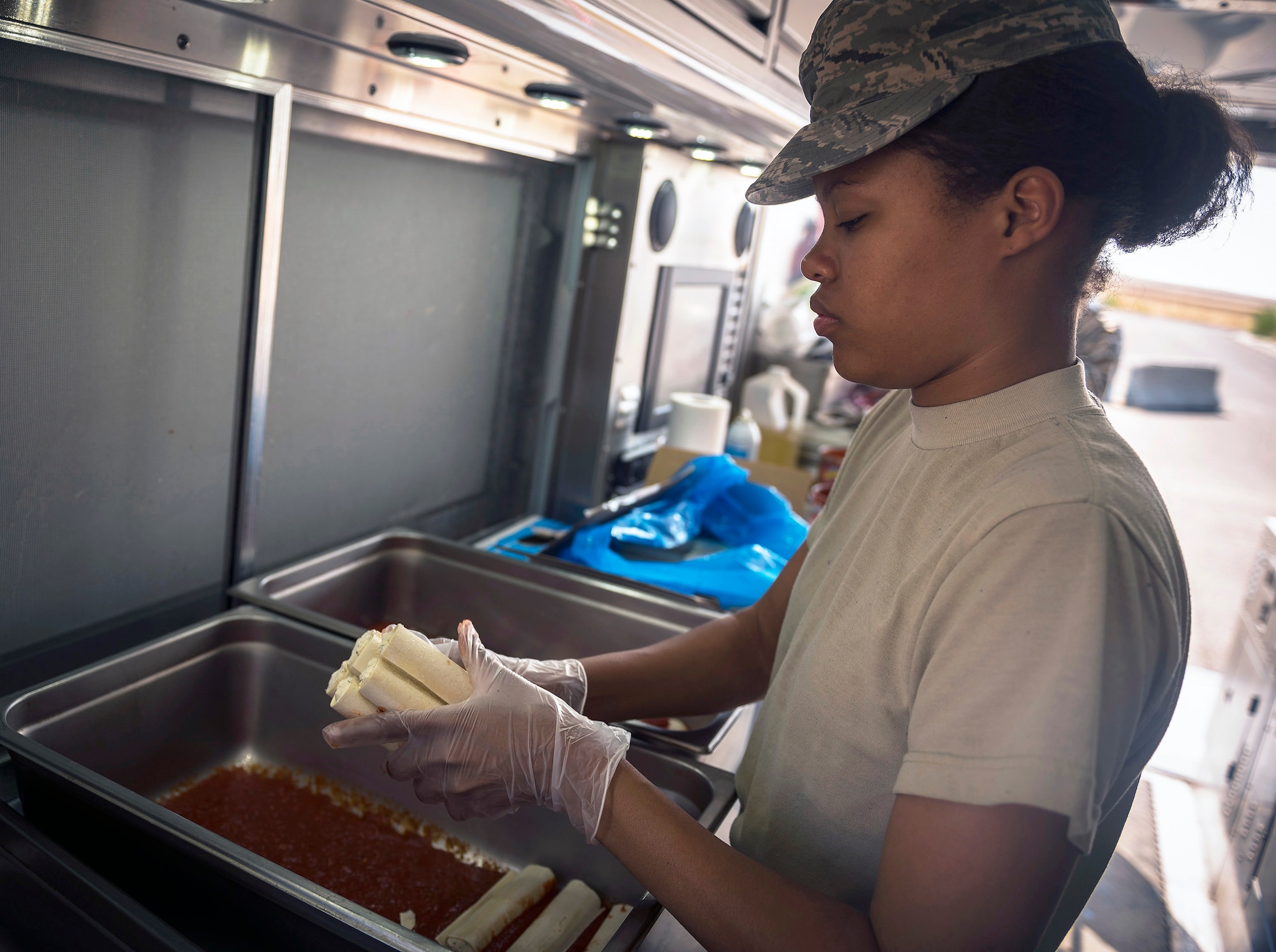 U.S. Air Force Airman 1st Class Starlyn Stratton, a services specialist with the 182nd Force Support Squadron, Illinois Air National Guard, prepares manicotti for dinner in Crow Agency, Mont., Aug. 1, 2017. She and seven other services specialists provided meal support to 182nd Civil Engineer Squadron Airmen building veterans’ homes for the Innovative Readiness Training program. (U.S. Air National Guard photo by Tech. Sgt. Lealan Buehrer)