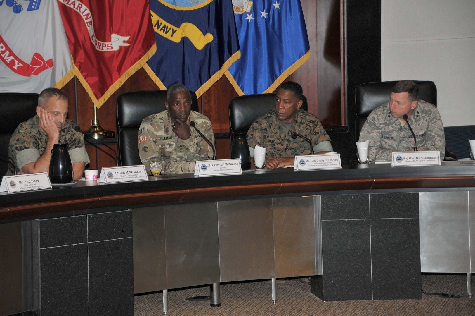 Four generals seated at table, facing viewer.