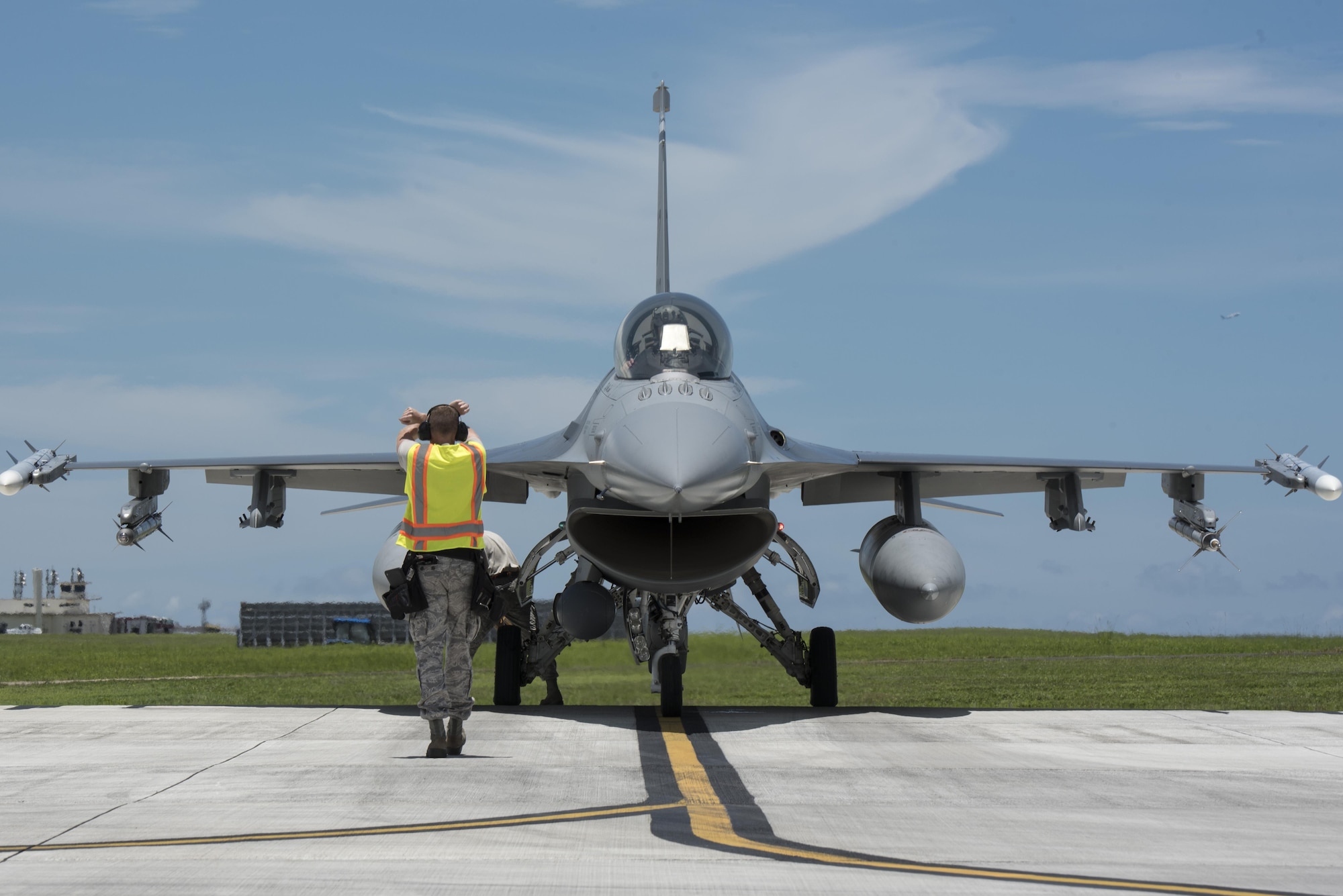 Airman on the flight line directing an F-16 aircraft