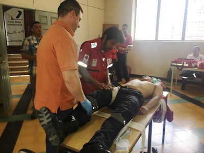 A member of the Honduran Red Cross demonstrates a patient assessment as Spc. Damien Allen, a medic from Brooke Army Medical Center, looks on July 22 during a four-hour pre-hospital training to share best practices. More than 40 Honduran Red Cross volunteers and paramedics participated in the training.
