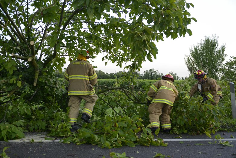 Fabrizio La Marca, Staff Sgt. Jason Holmes and Tech. Sgt. Brian Martenis, 31st Civil Engineer Squadron firefighters, pull debris off a highway Aug. 10, 2017, in Pordenone Province, Italy. The 31st CES firefighters teamed with local first responders to clear roadways after heavy thunderstorms passed through the area. (U.S. Air Force photo by Tech. Sgt. Andrew Satran)